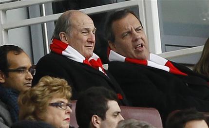  New Jersey Gov. Chris Christie, right, wearing an Arsenal scarf, sits with Rutgers University President Robert Barchi in the stands during the English Premier League soccer match between Arsenal and Aston Villa at the Emirates stadium in London, Sunday, Feb. 1, 2015. Christie, a likely Republican candidate for president, said Monday that parents should have some choice on whether to vaccinate their children. (AP Photo/Kirsty Wigglesworth)