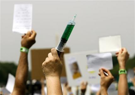 In this Wednesday, June 4, 2008 file photo, a woman holds up a syringe with symbolic green fluid during a rally on Capitol Hill in Washington calling for the elimination of what demonstrators say are toxins in children's vaccines. Parents have been nervous about vaccines for as long as vaccines have been around. Opposition seemed to plummet for several decades, as vaccines got better and succeeded in beating back diseases, but parental concern has seemed to be on an upswing in the last 20 years. (AP Photo/Jose Luis Magana)