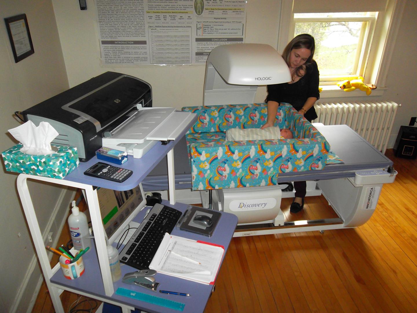 Research nurse setting up the bone densitometer to take an x-ray of an infant's muscle and bone. Source: Hope Weiler, McGill University