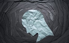 Silhouette of depressed and anxiety person head. Negative emotion image. Person head shaped paper on black torn paper background.