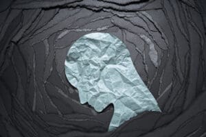 Silhouette of depressed and anxiety person head. Negative emotion image. Person head shaped paper on black torn paper background.