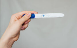 positive pregnancy test in the hands of a girl close-up