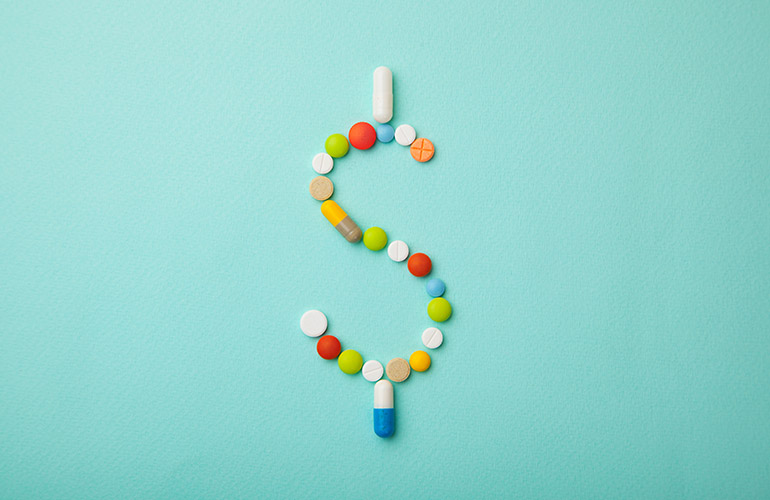 Symbol of money dollar from colored pills and capsules on green background. Expensive medicine and medical insurance